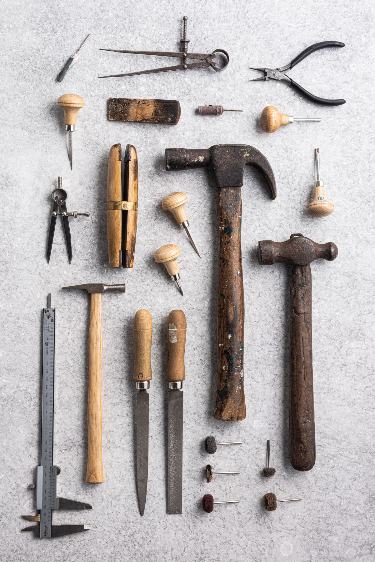 Flat lay of jewellery making tools from Betsy Blonde studio including hammers and files and pliers 